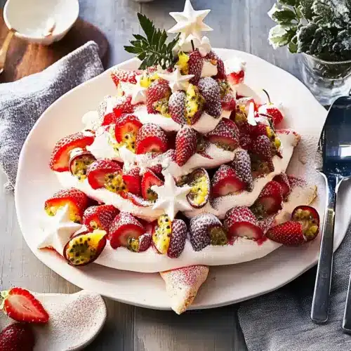 Pavlova Christmas tree topped with strawberries and passionfruit